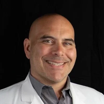 A professional headshot photo of Dr. Joseph Arevalo, a chiropractor at the Doctor Arevalo clinic